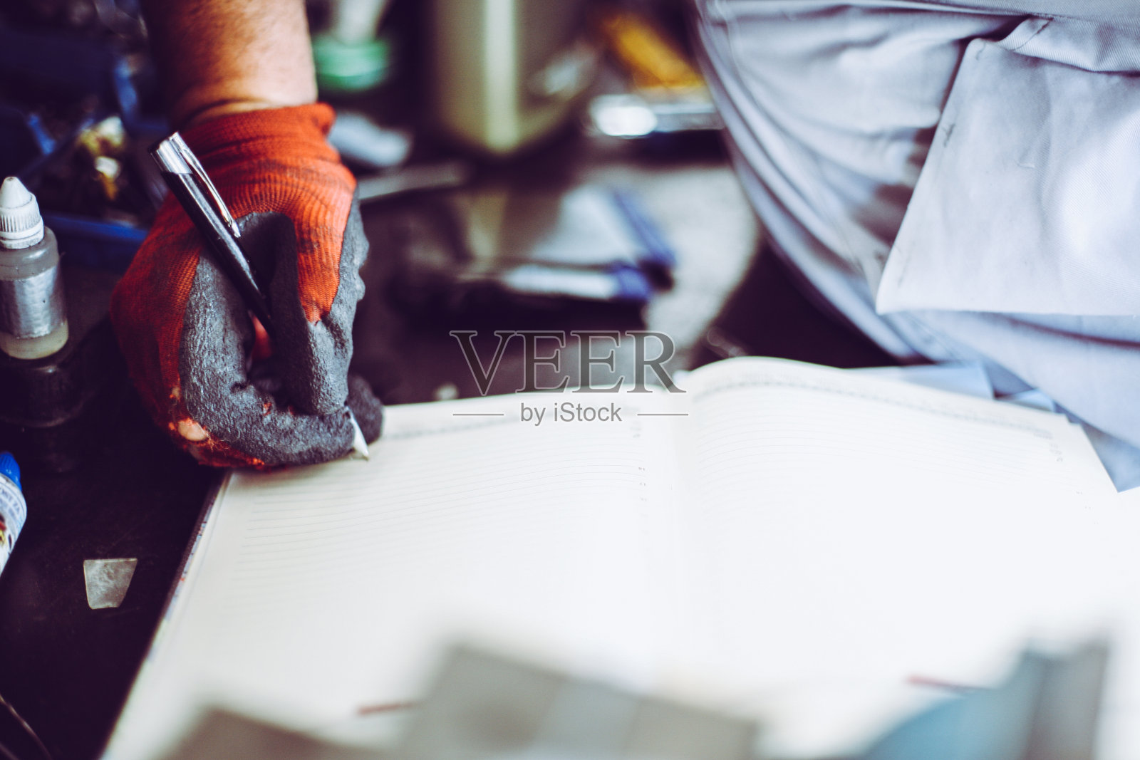 车间高级人员。人在笔记上写下义务。关闭了。照片摄影图片