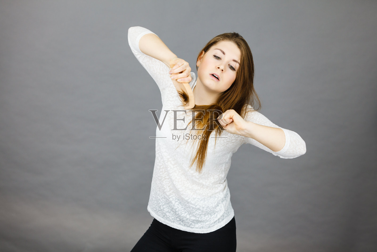 愤怒的女人试图梳理她的头发照片摄影图片