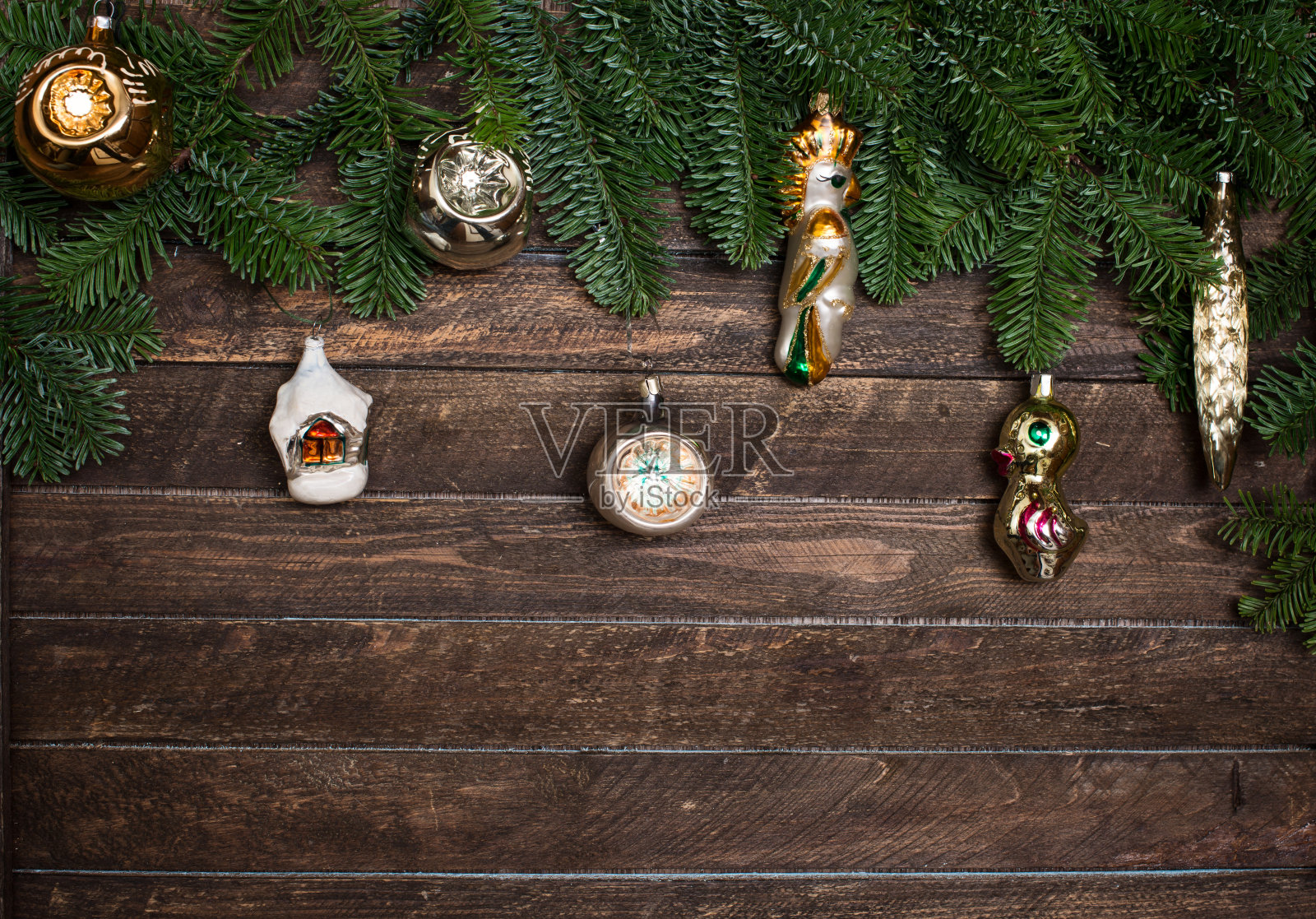 一套旧的复古玩具装饰与圣诞节树枝在木制的乡村背景。新年的背景照片摄影图片