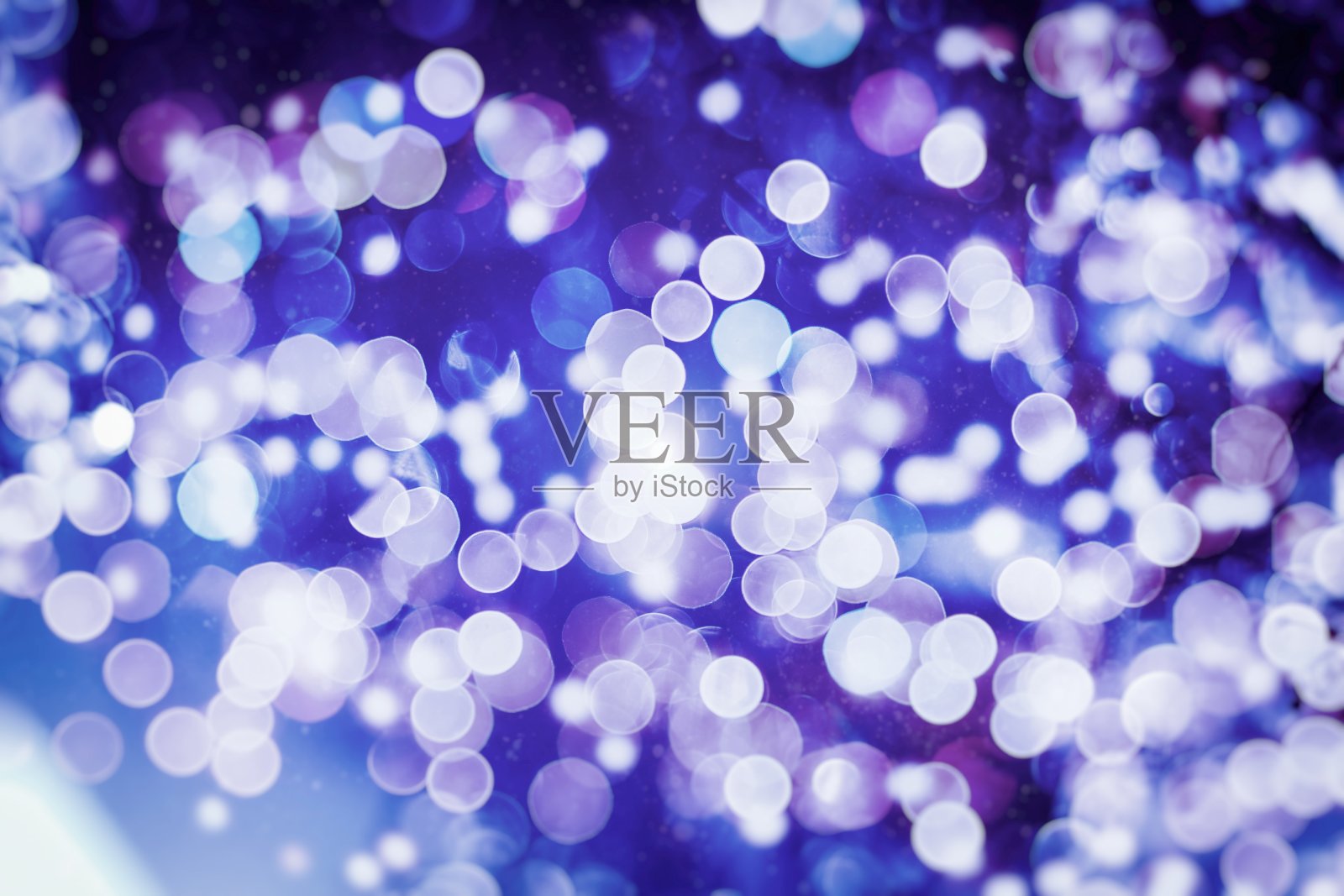 抽象模糊的蓝色和银色闪烁的灯泡灯光背景:模糊的圣诞墙纸装饰概念。圣诞节日背景:闪烁圈点亮庆典展示。照片摄影图片