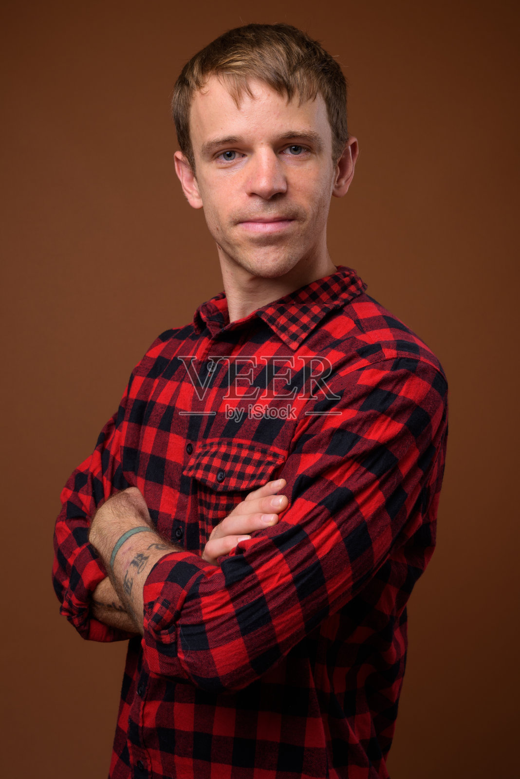 在彩色背景下，一名男子穿着红色格子衬衫照片摄影图片