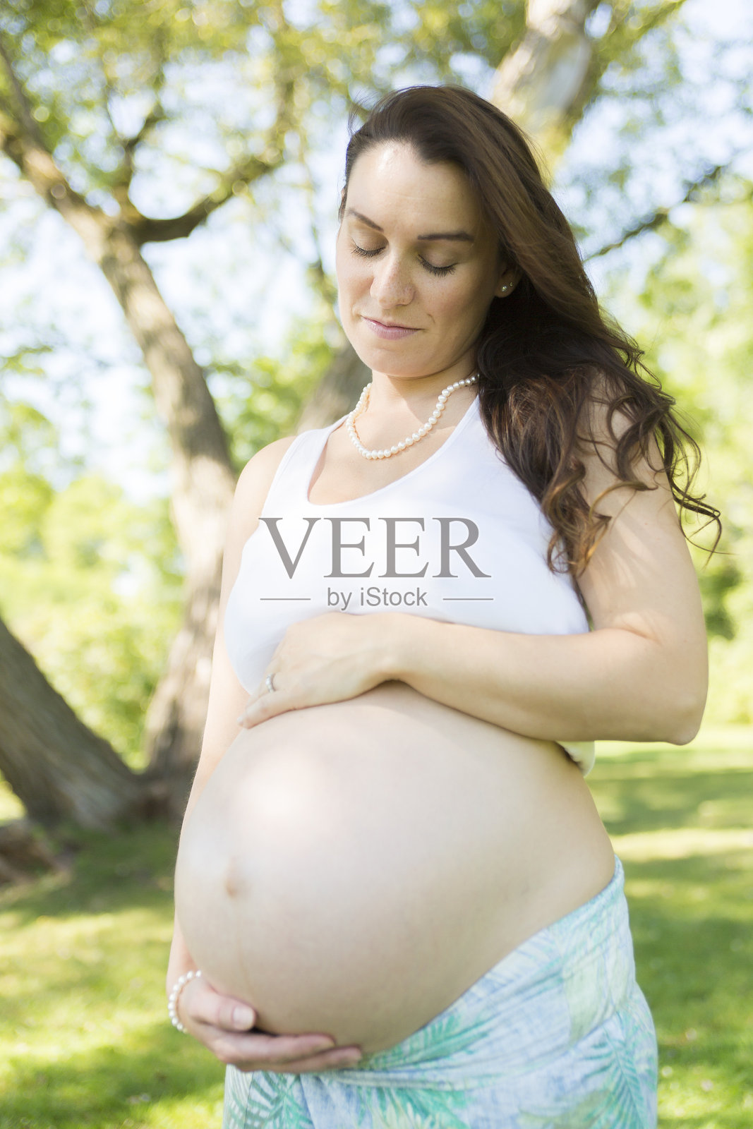 年轻漂亮的孕妇，留着长发照片摄影图片