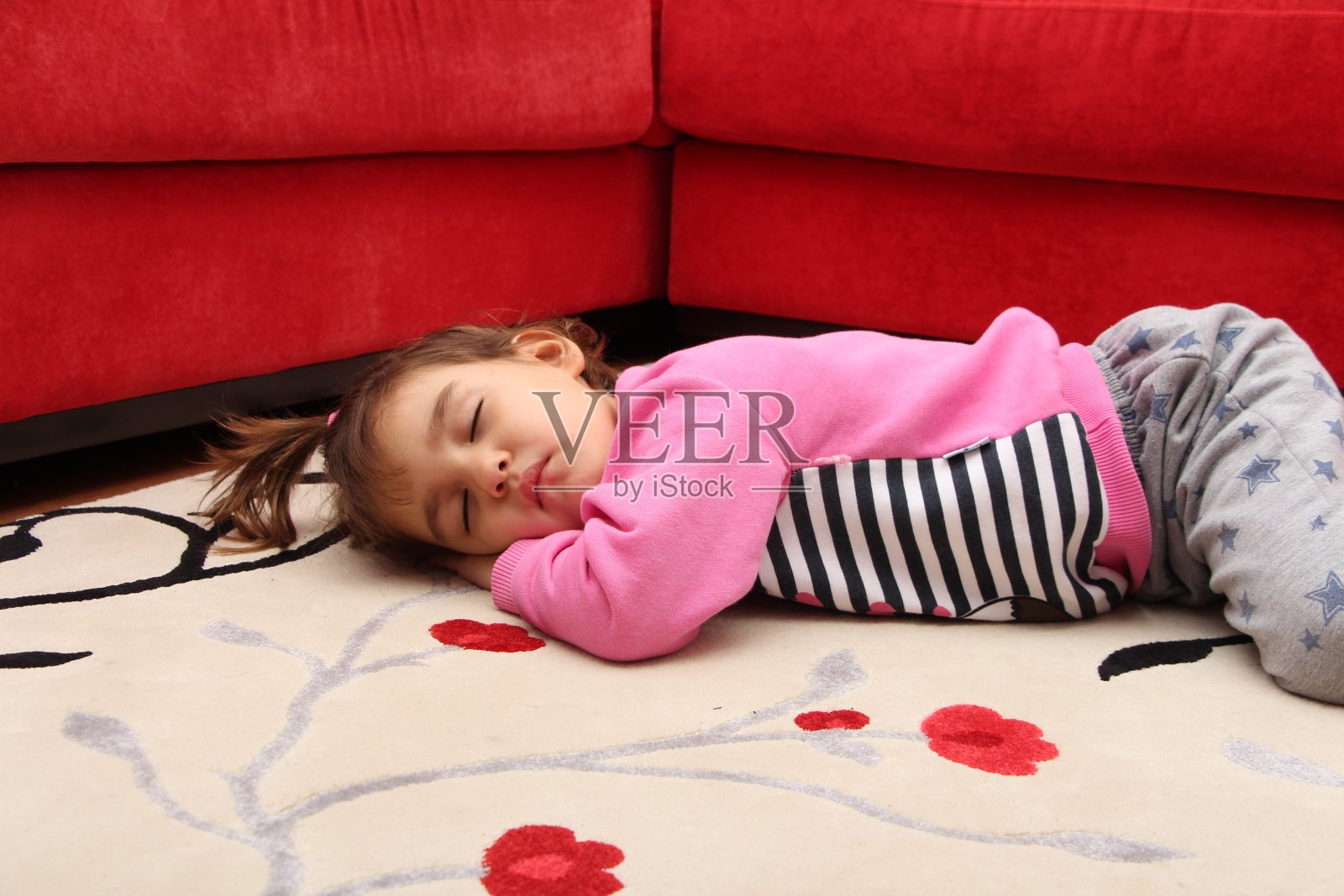 小孩睡在地毯上照片摄影图片
