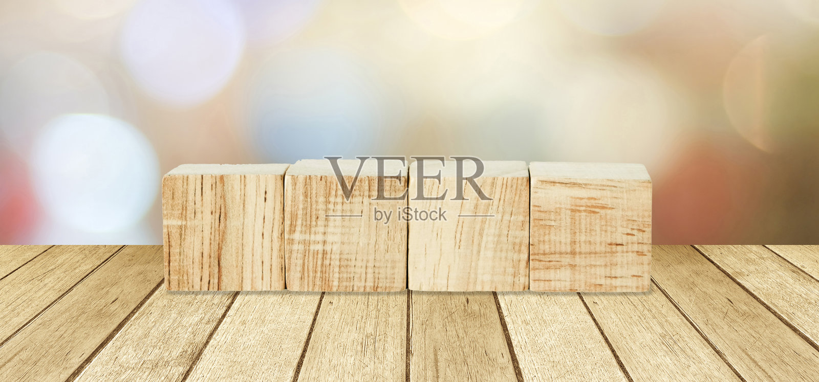 四个木制立方体在透视木材上，模糊抽象的散景光背景照片摄影图片