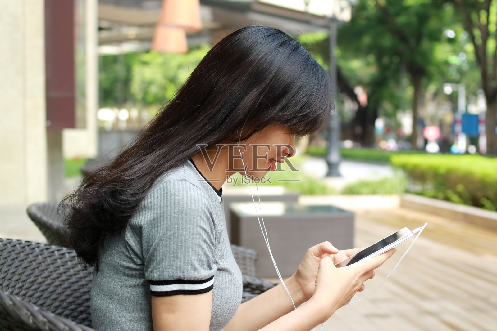 一个年轻女孩在越南用智能手机听音乐照片摄影图片