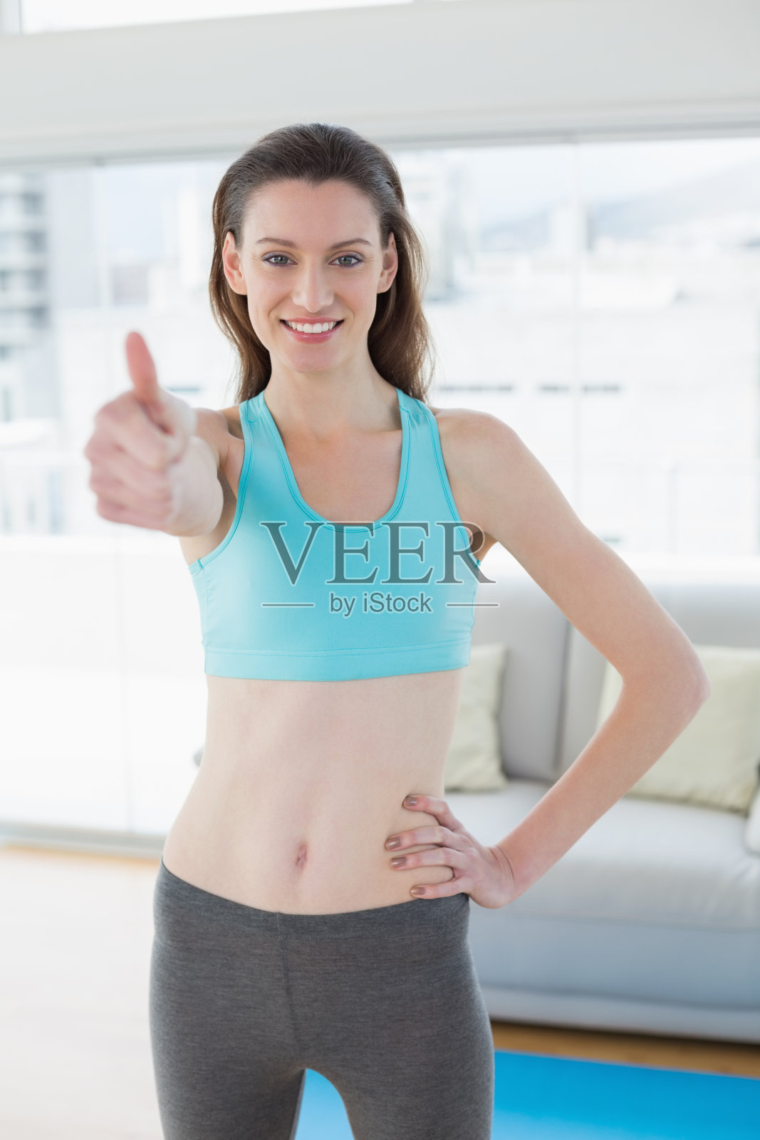 健美的女人在健身房里竖起大拇指照片摄影图片