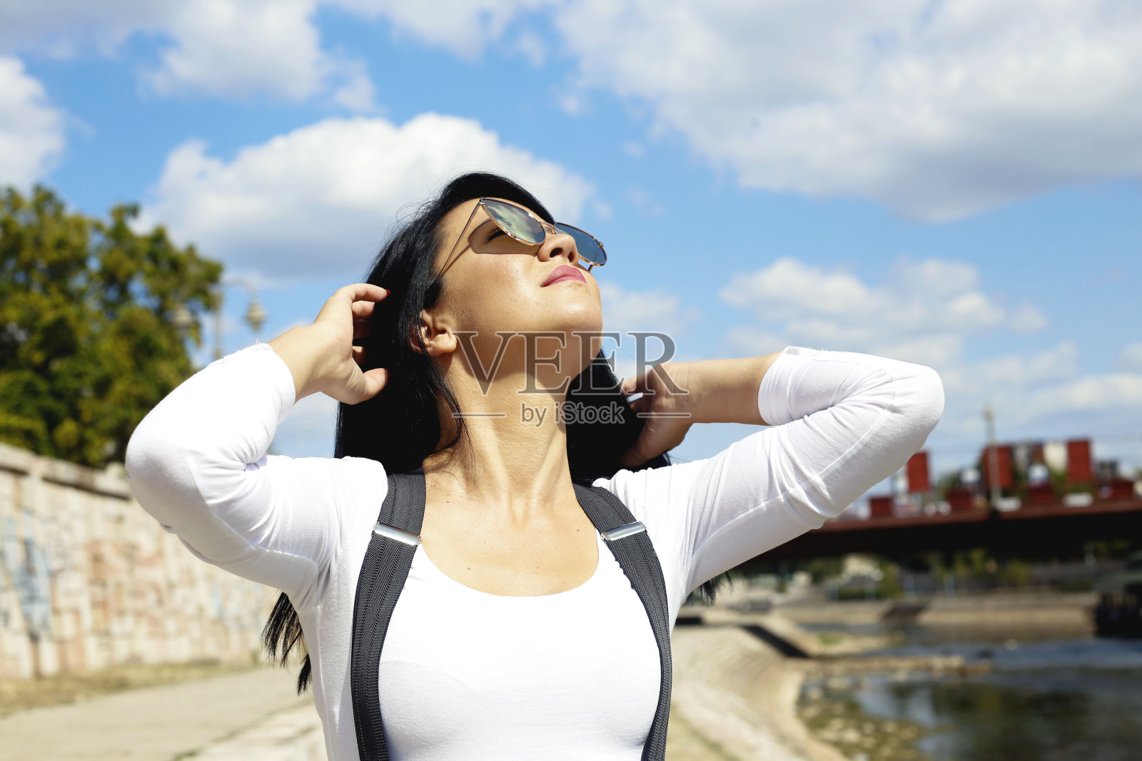 美丽的年轻女子享受在阳光明媚的一天附近的河照片摄影图片
