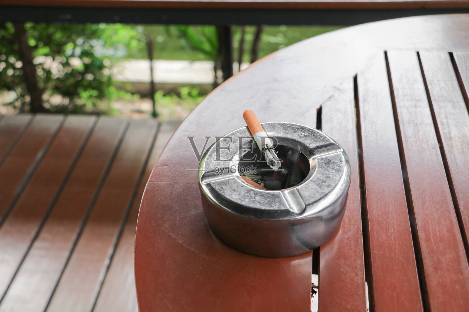 烟灰缸中的香烟放在桌子的木头背景上照片摄影图片