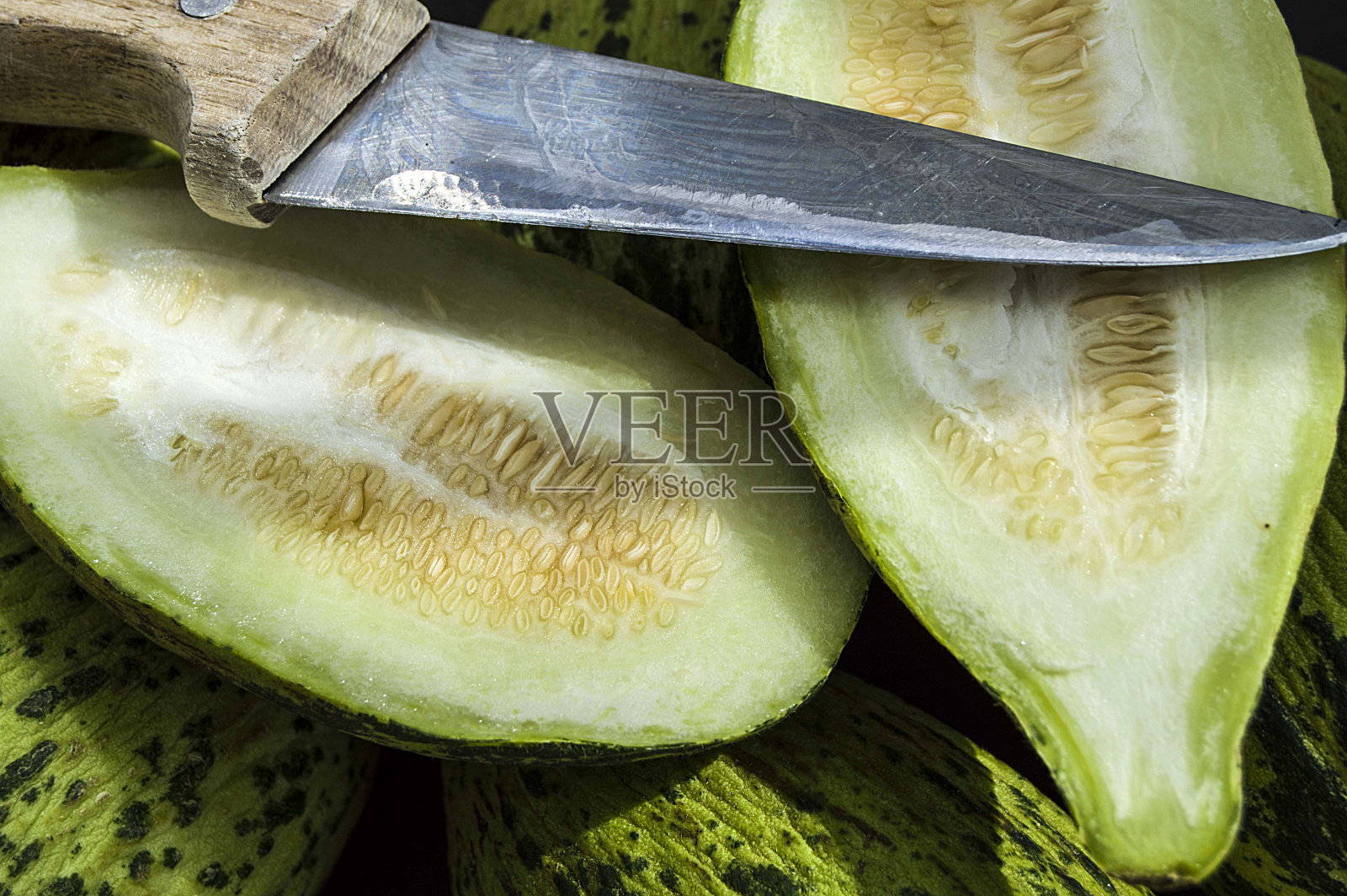 全未熟小甜瓜，生甜瓜图片，用刀切一个小甜瓜，吃一个未熟的甜瓜，未熟的小甜瓜，照片摄影图片