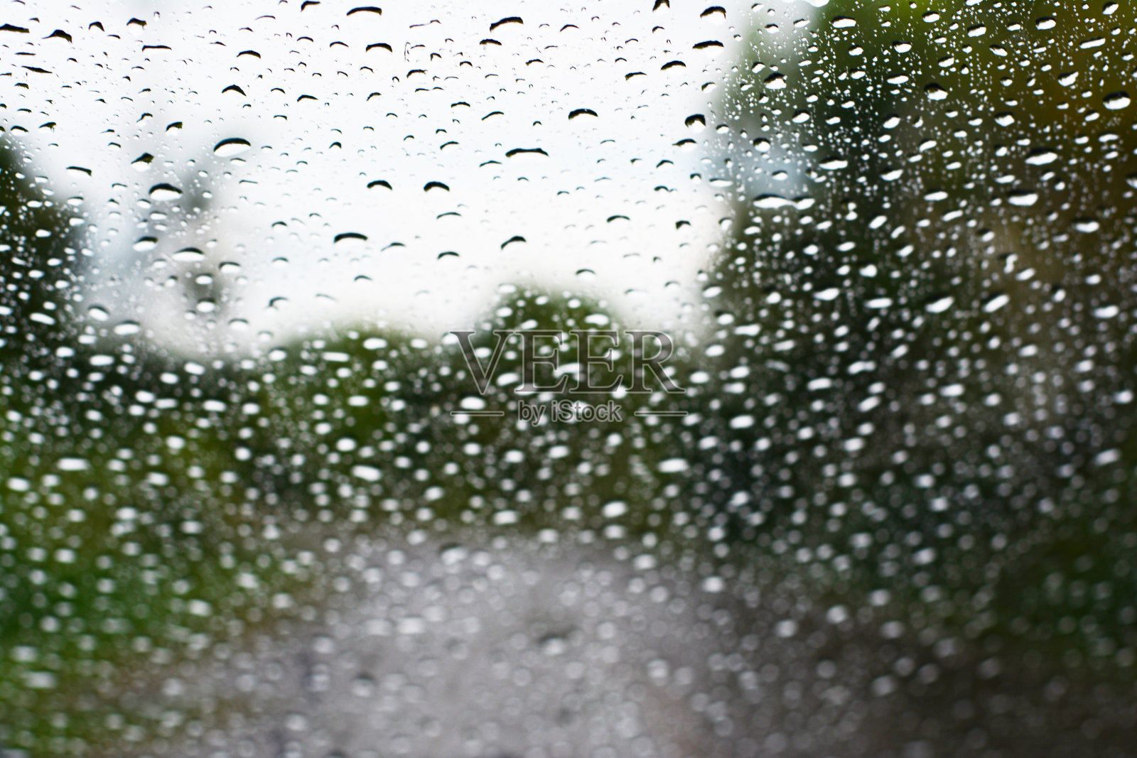 雨的模糊背景和沿途的树木与天空照片摄影图片