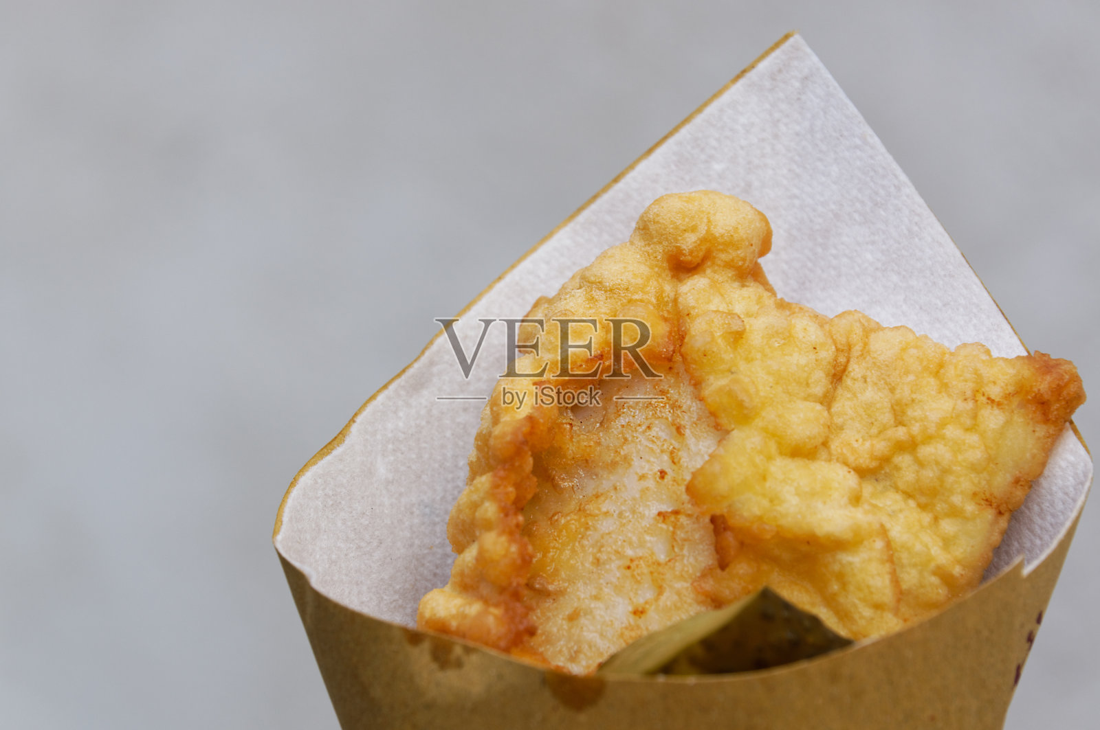 虾，土豆和蔬菜面糊，油炸。硬纸板包装的街头小吃。照片摄影图片