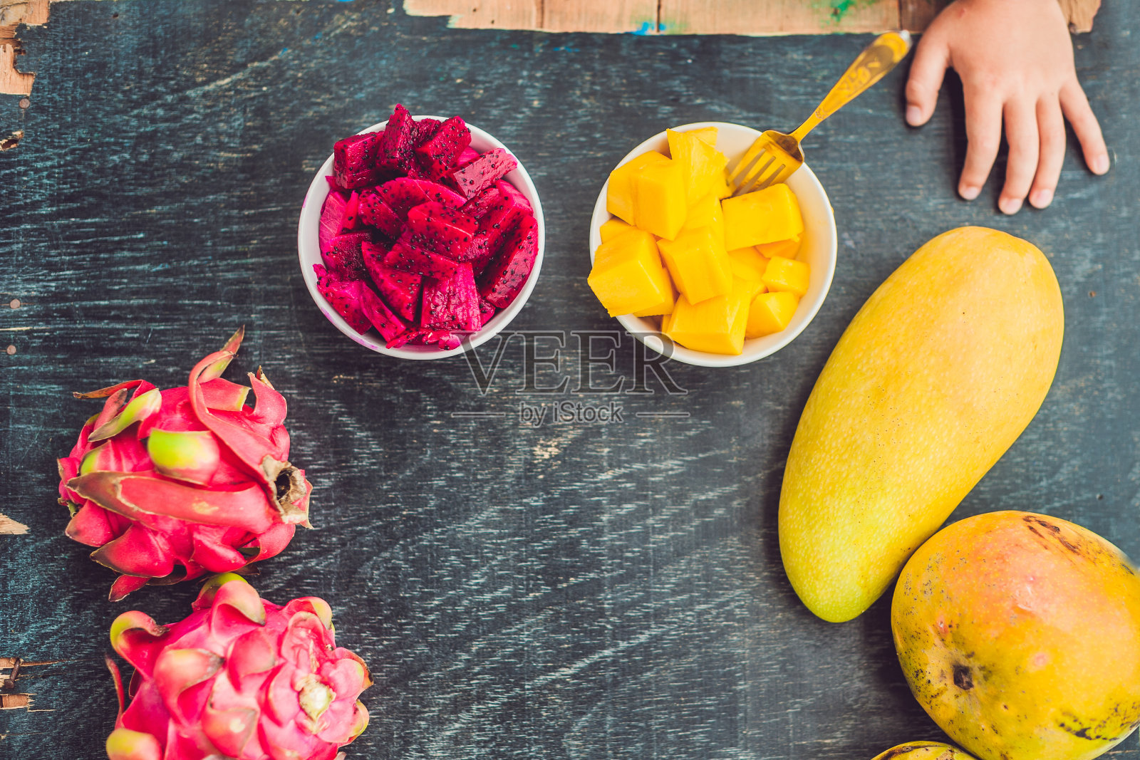 可爱的小男孩在阳台上吃芒果照片摄影图片