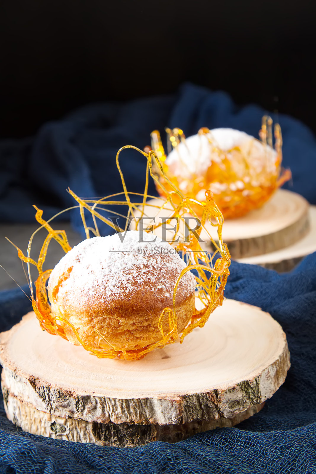 意大利甜点是奶油和焦糖装饰的奶油卷。黑暗的背景。照片摄影图片