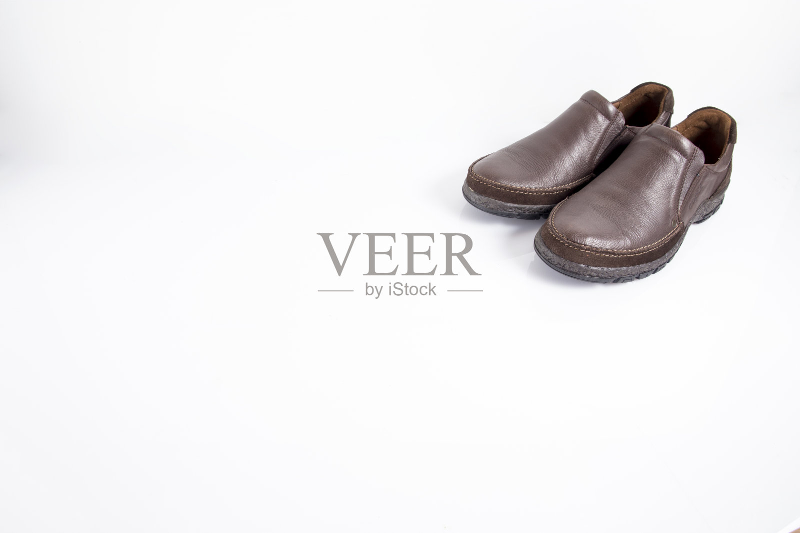 白色背景上的男性棕色皮鞋照片摄影图片