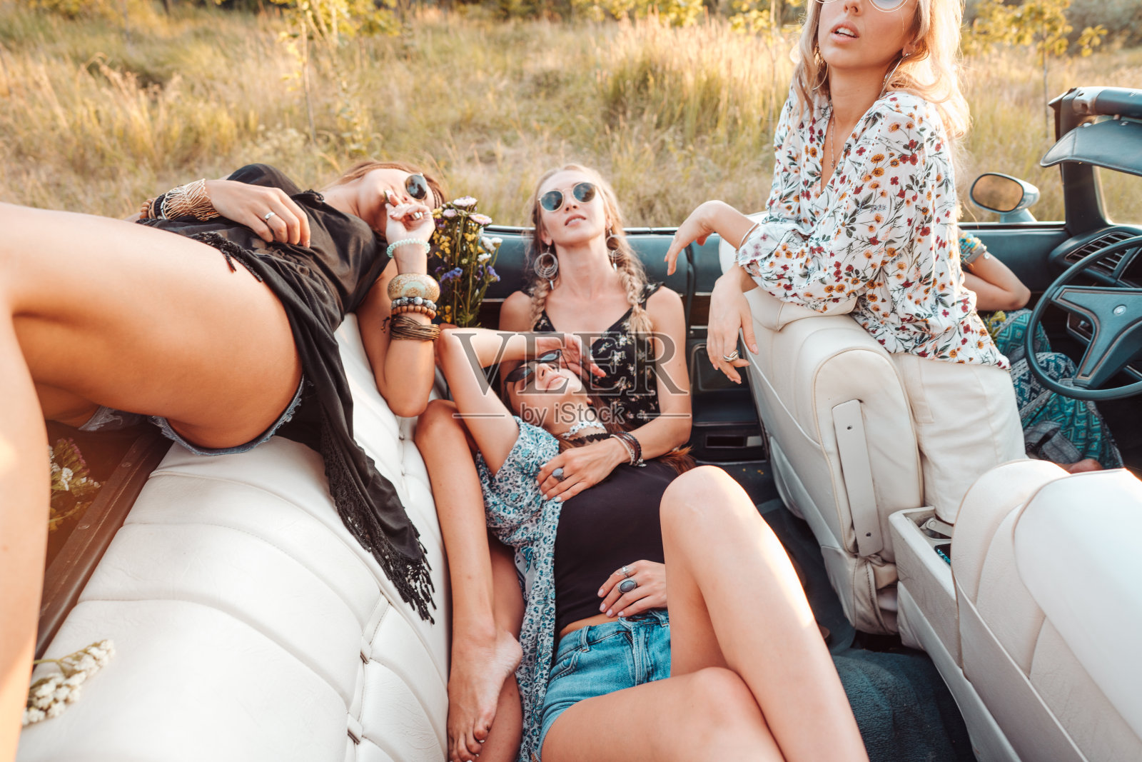 女孩们躺在演出台上，在镜头前摆姿势照片摄影图片