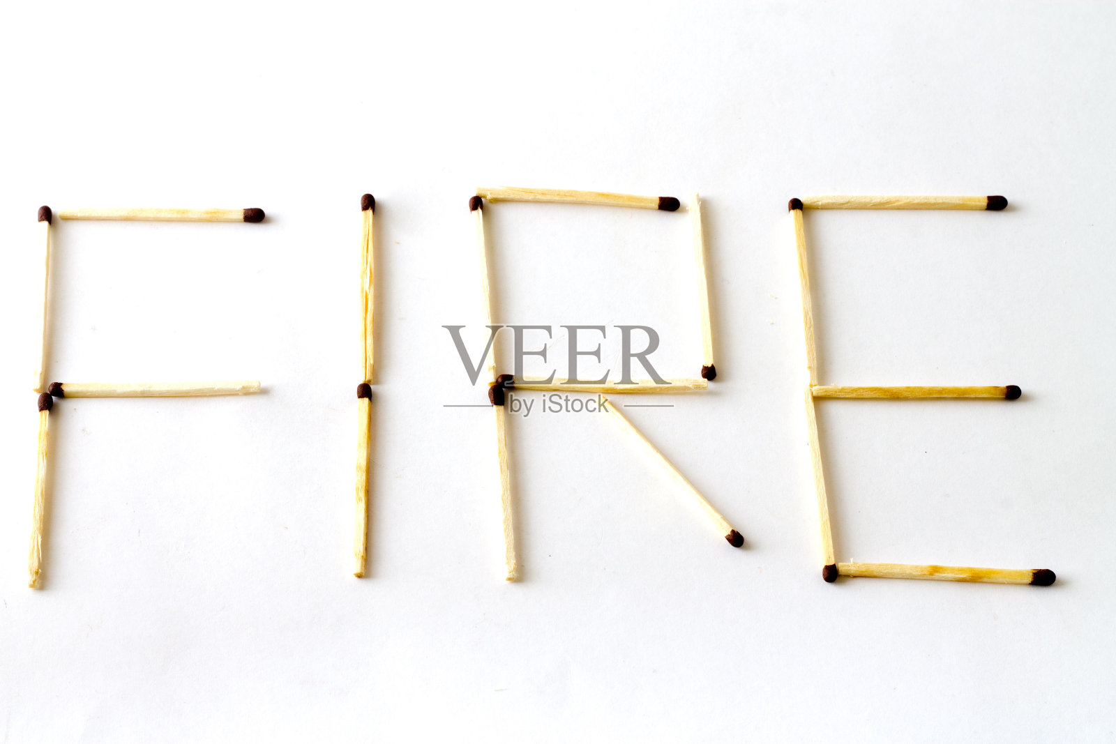 白色背景上用火柴棍刻字“火”照片摄影图片