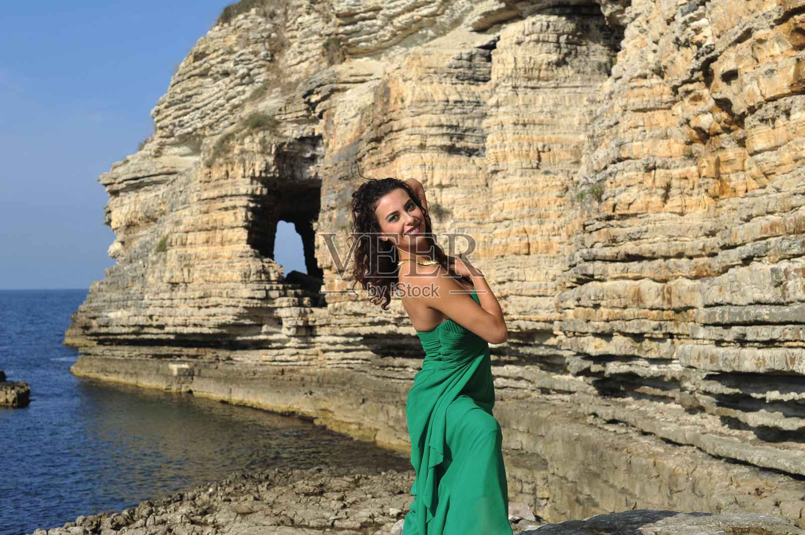 年轻的时尚模特在大自然与绿色晚礼服照片摄影图片