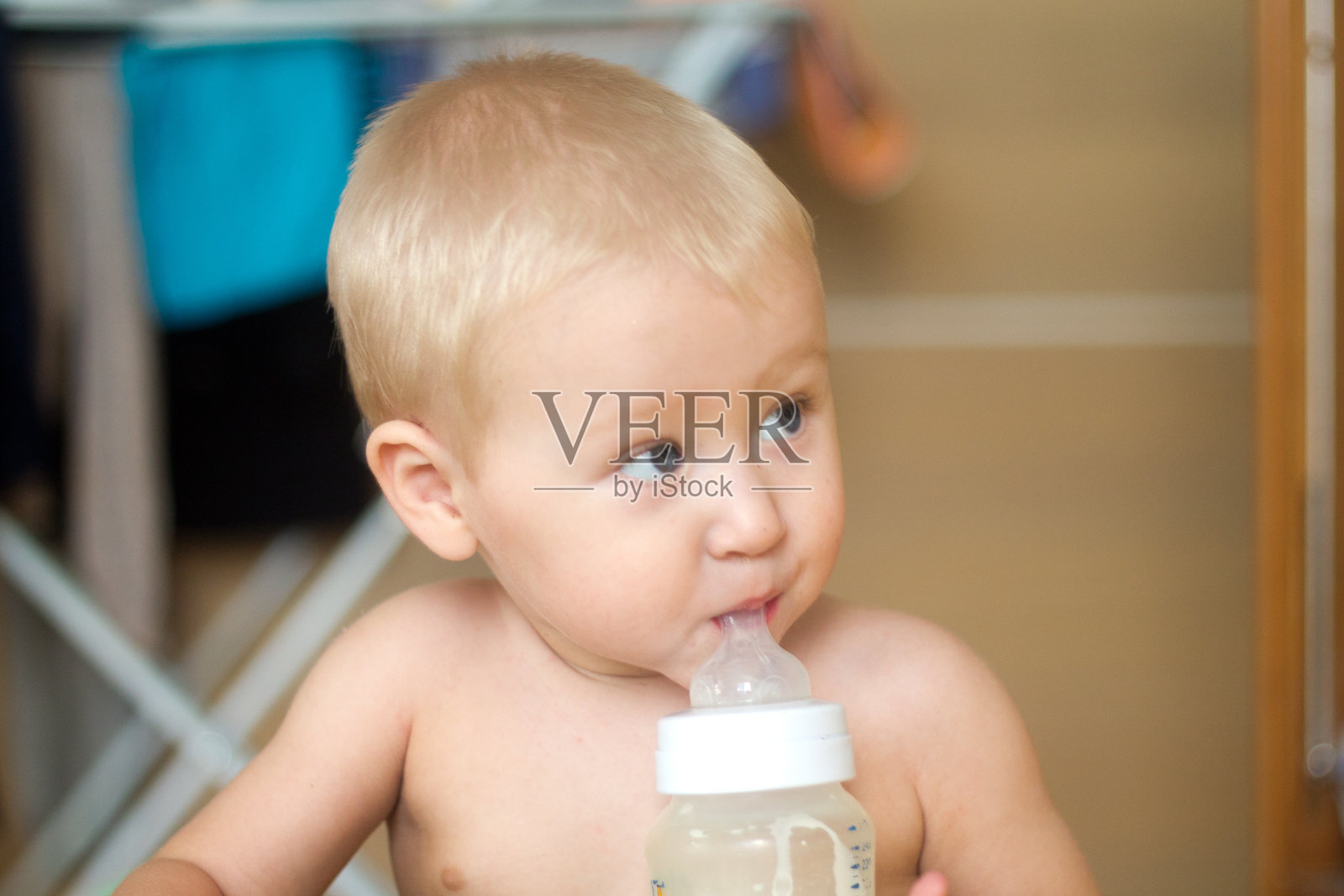 金发小孩用奶嘴喝婴儿配方奶粉照片摄影图片