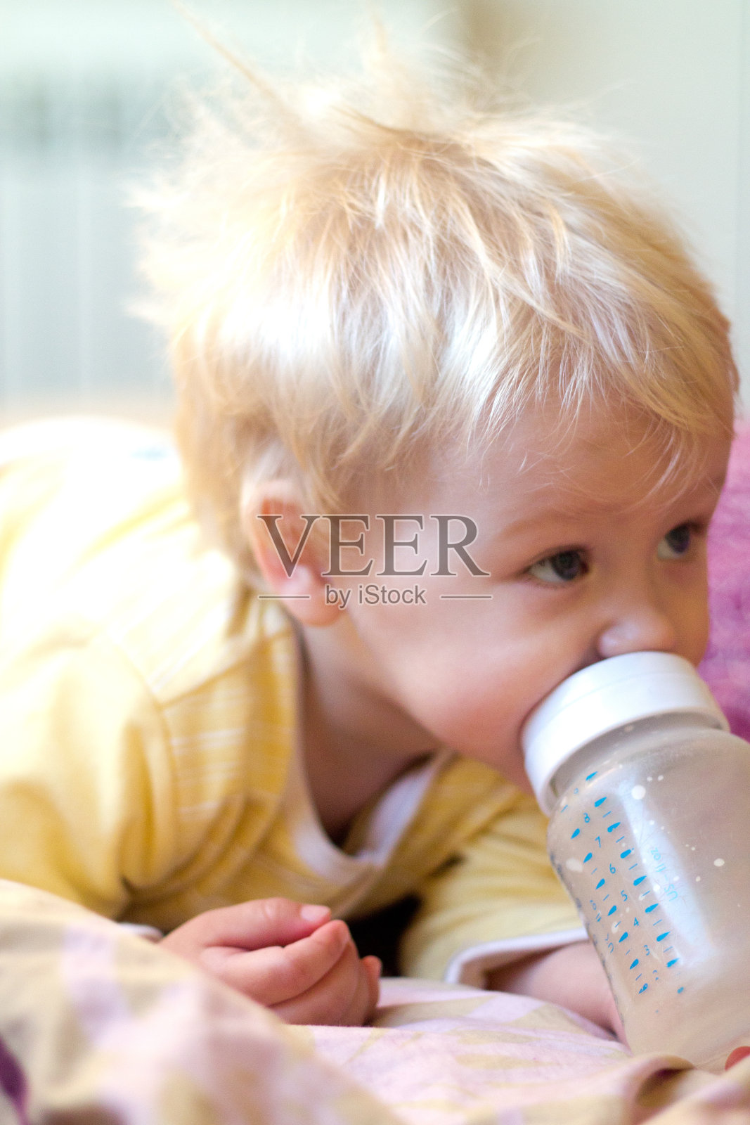 金发小孩用奶嘴喝婴儿配方奶粉照片摄影图片