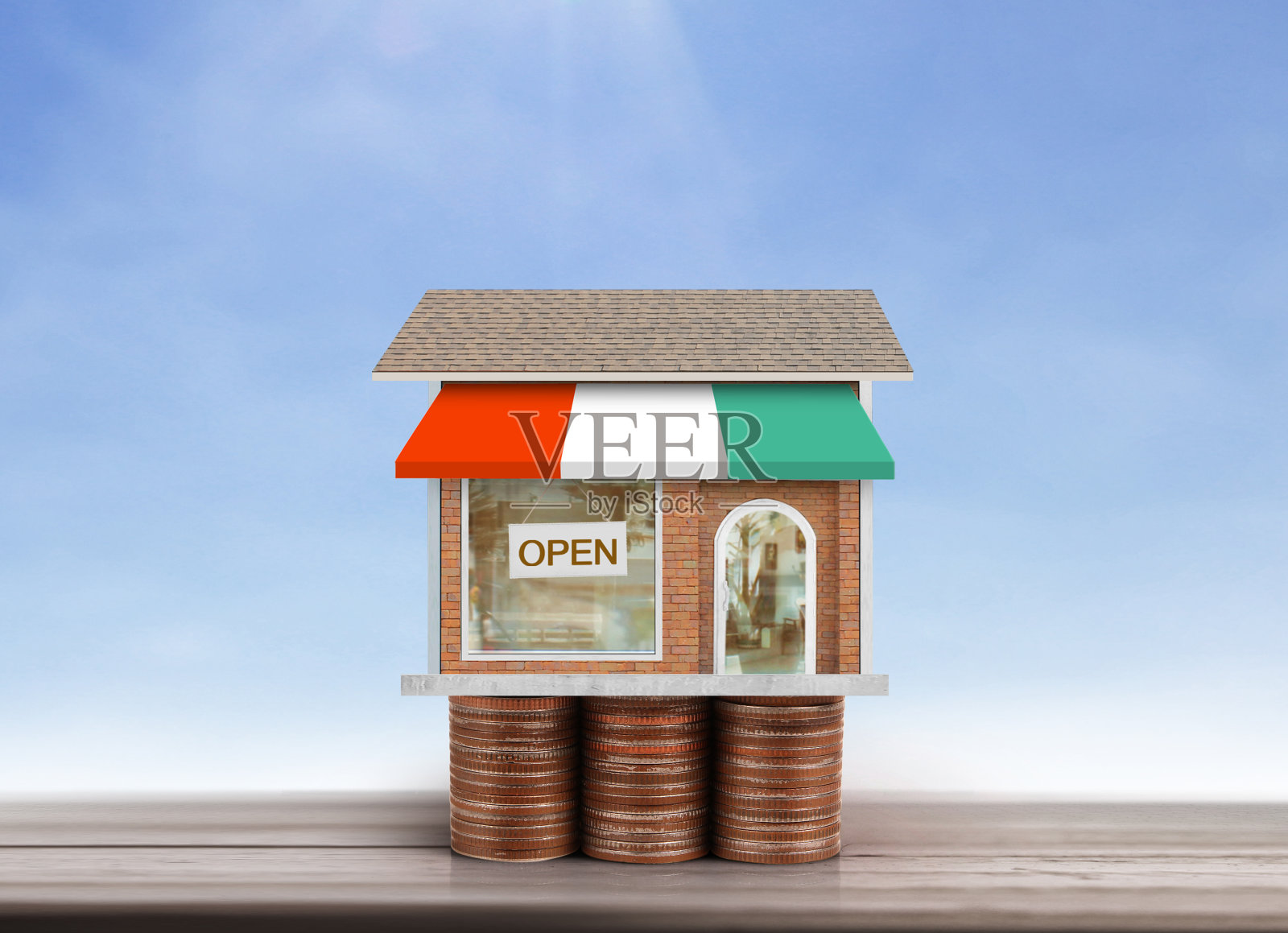 站在硬币堆上的小房子照片摄影图片