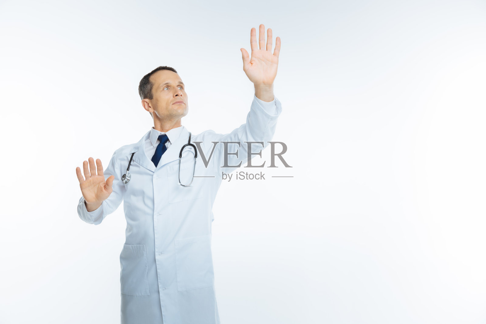 成熟的男医生试图触摸看不见的屏幕照片摄影图片