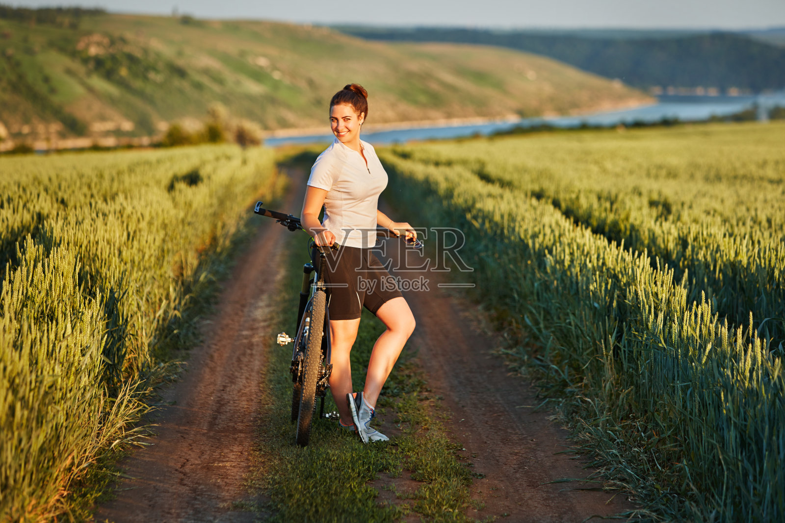 骑着自行车的女人在美丽的草地上享受暑假照片摄影图片