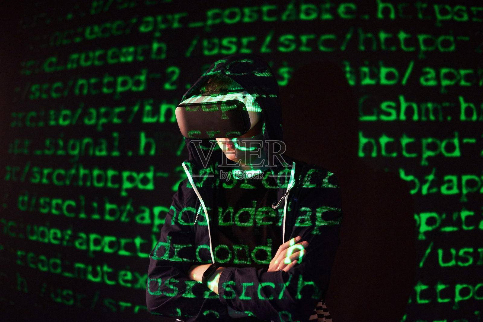 一个白种人和虚拟现实头盔的双重暴露可能是一个玩家或黑客在破解一个安全网络或服务器的代码，用行代码照片摄影图片