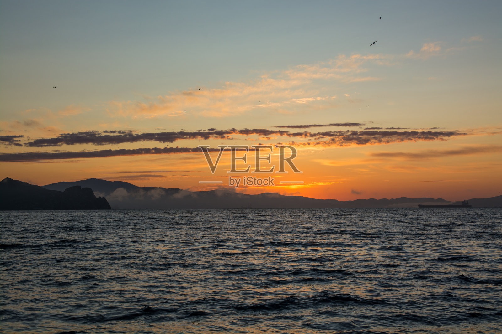 橙色的夕阳和黑色的湖水。照片摄影图片