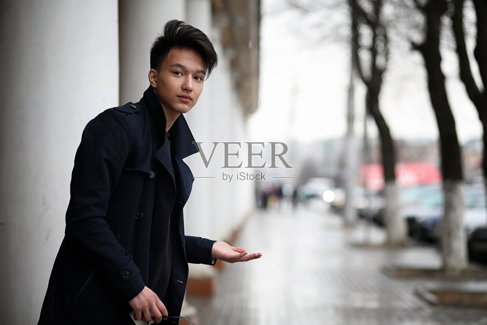 穿着外套的亚洲年轻人在街上照片摄影图片