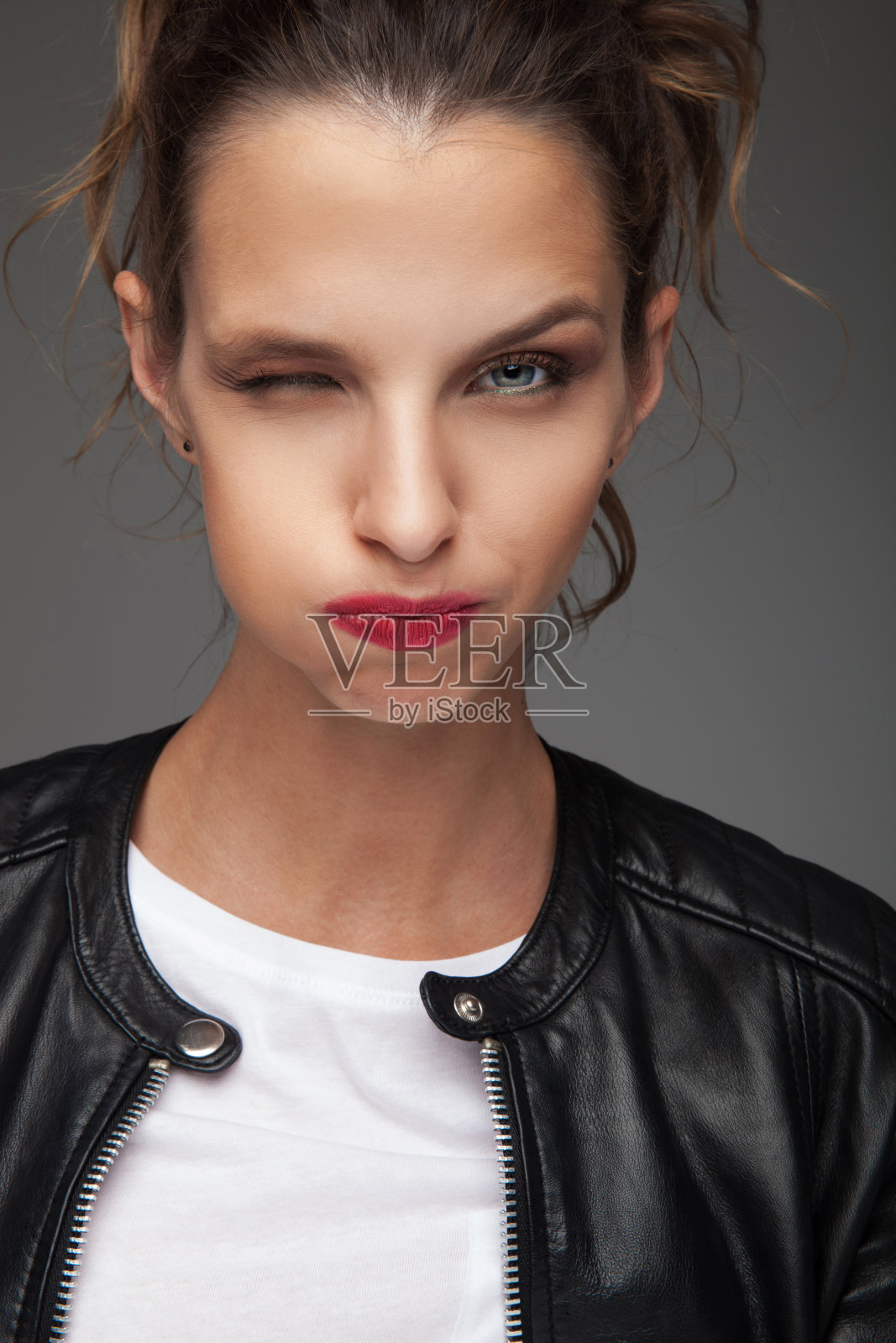 那个穿皮夹克的女人，又眨眼又鬼混照片摄影图片