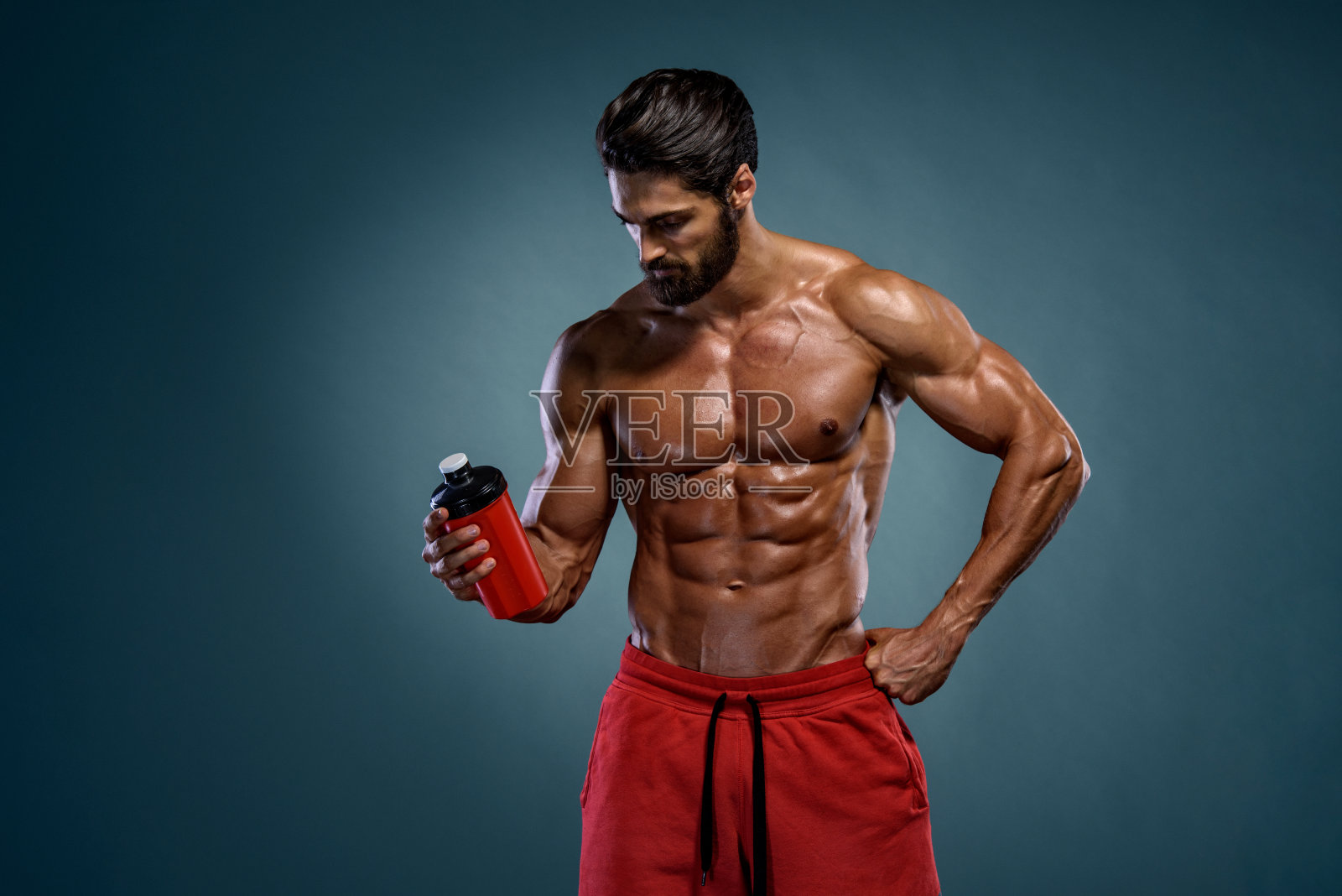 肌肉男喝他的营养补充品照片摄影图片