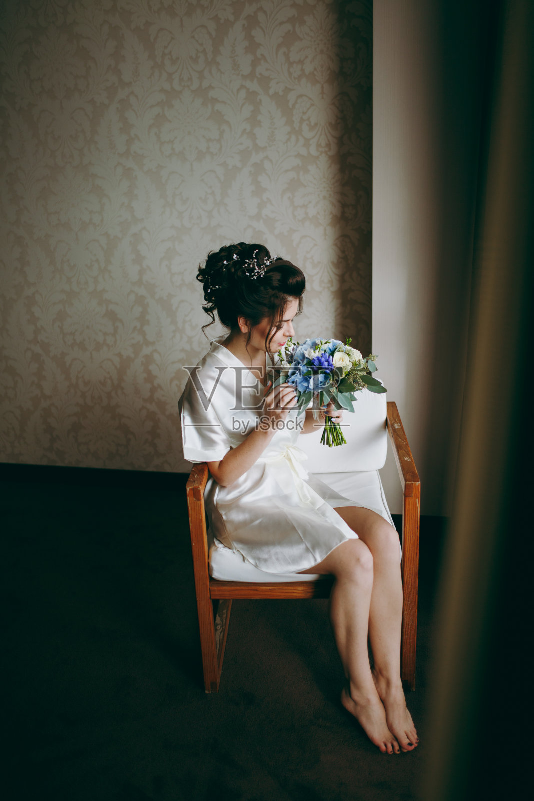 美丽的新娘捧着花束坐在椅子上照片摄影图片