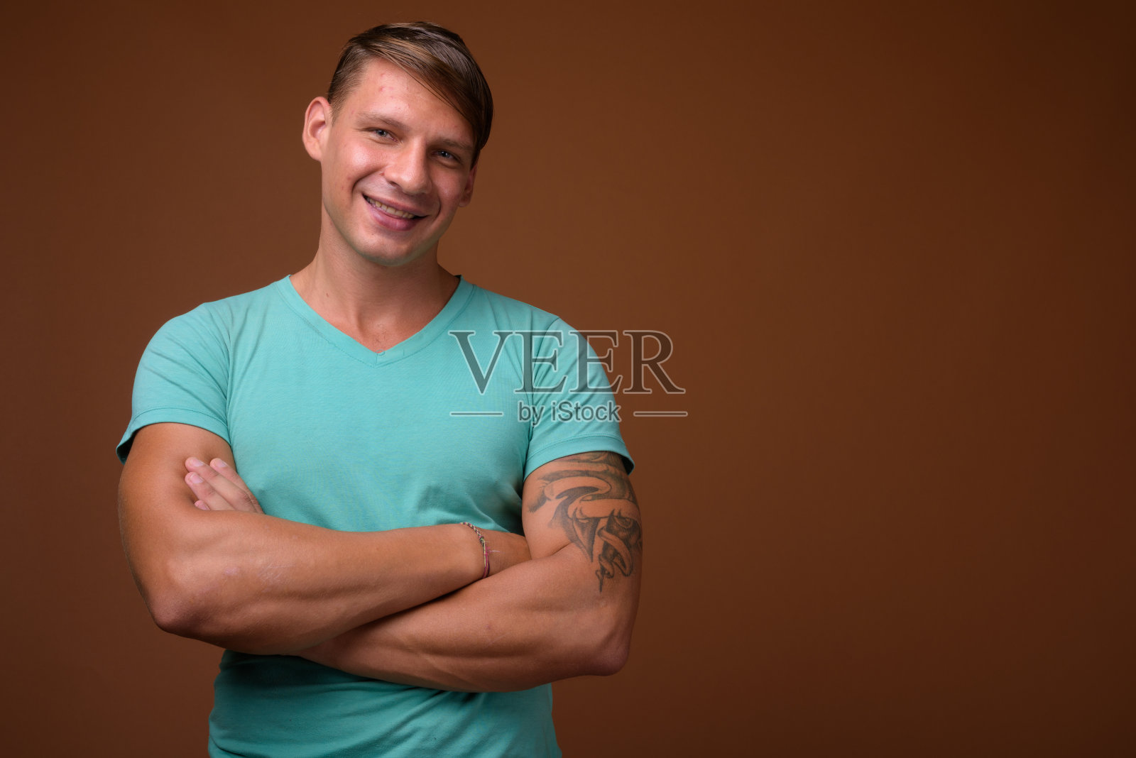 摄影棚里的肌肉男穿着蓝色衬衫，背景是彩色的照片摄影图片