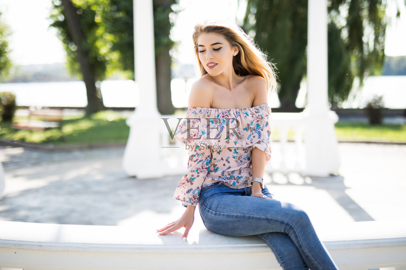 夏日公园里凉亭扶手上的漂亮女孩照片摄影图片