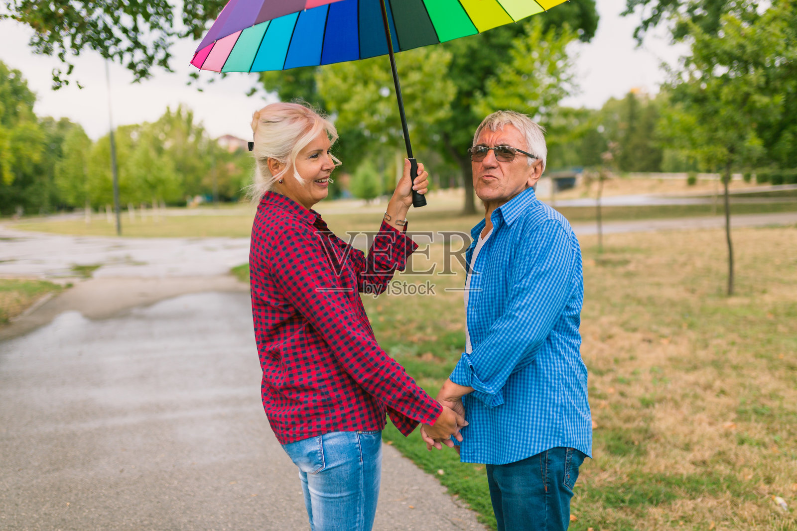 雨中打着伞的老夫妇照片摄影图片