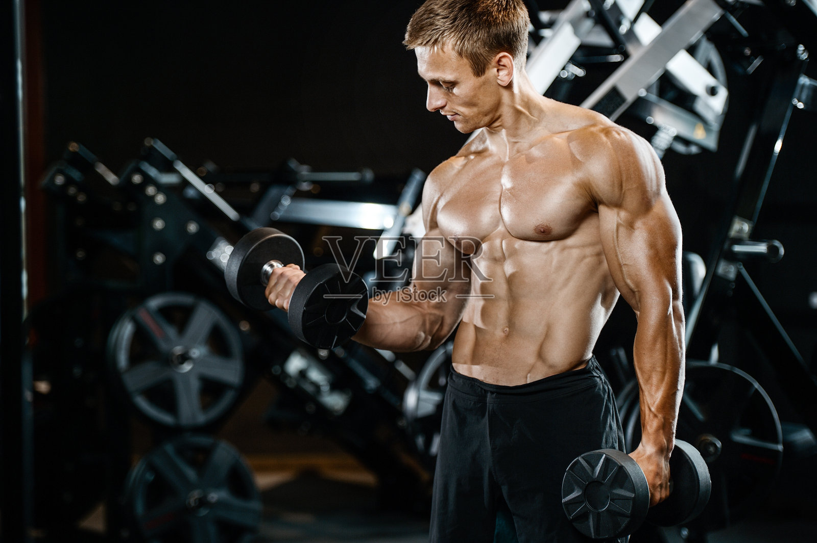 英俊的模特年轻男子在健身房锻炼照片摄影图片