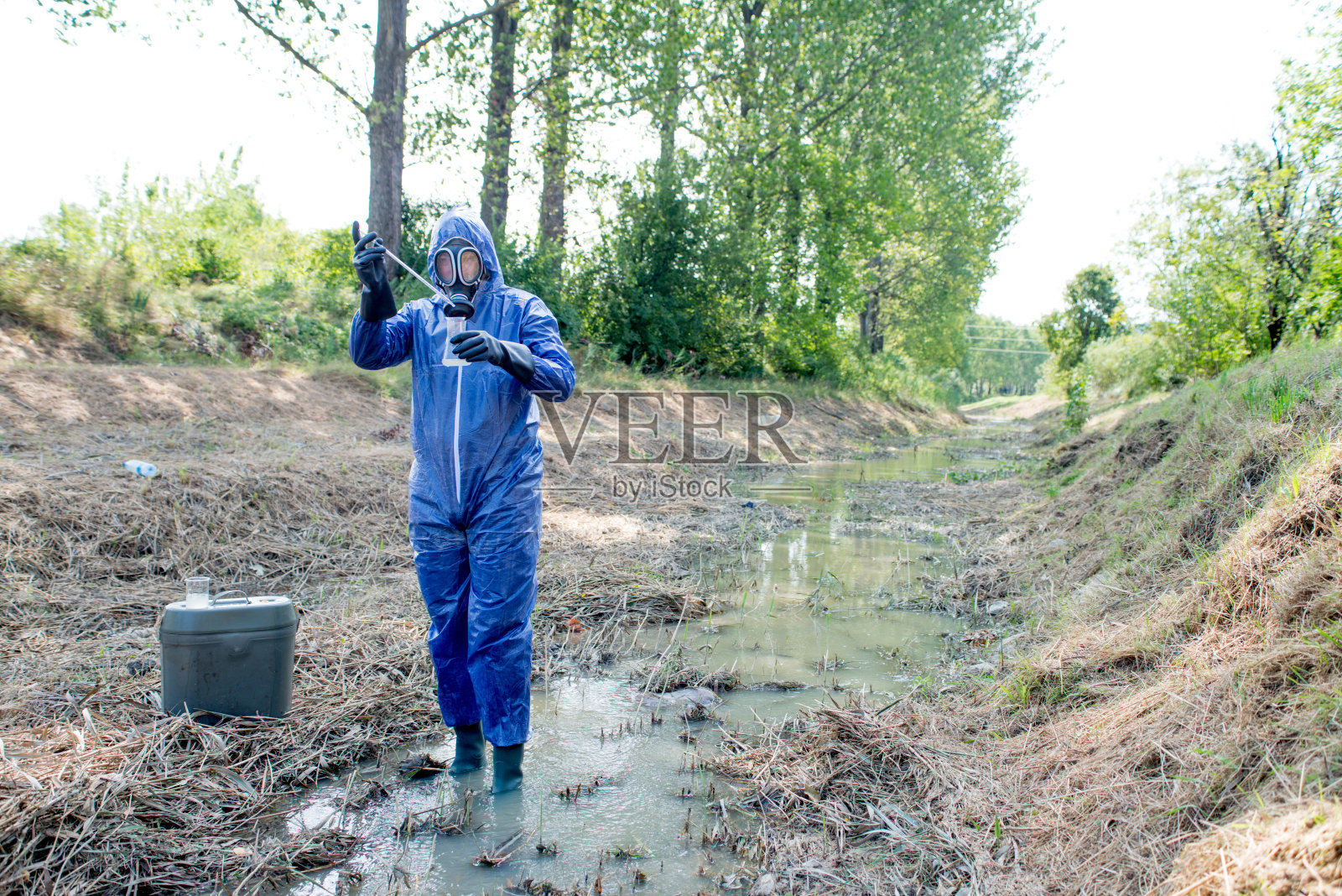 成年男子穿着防护服并采集水样照片摄影图片