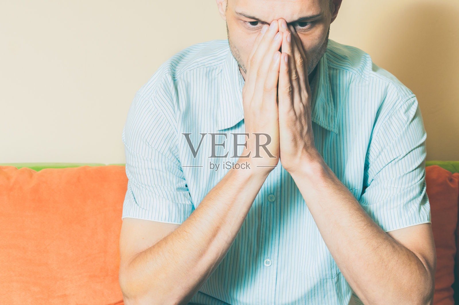 年轻帅气男子用手捂着脸，在思考人生时感到沮丧和痛苦照片摄影图片