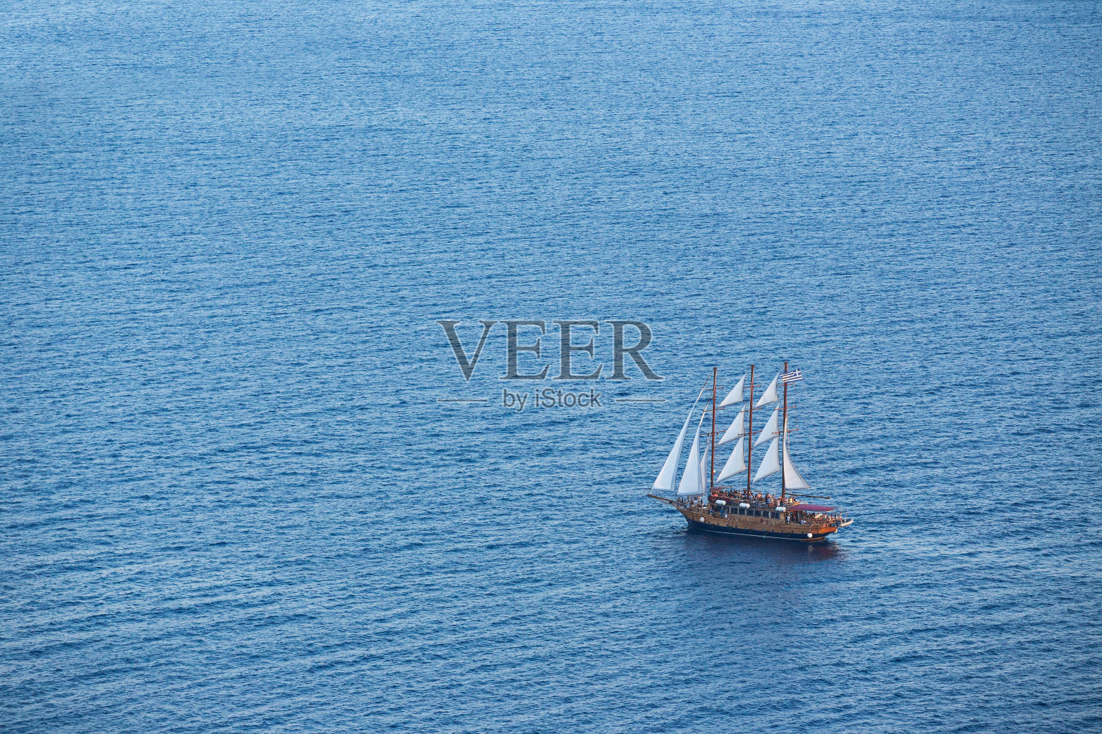 希腊圣托里尼岛深蓝色海水中的旧木船照片摄影图片