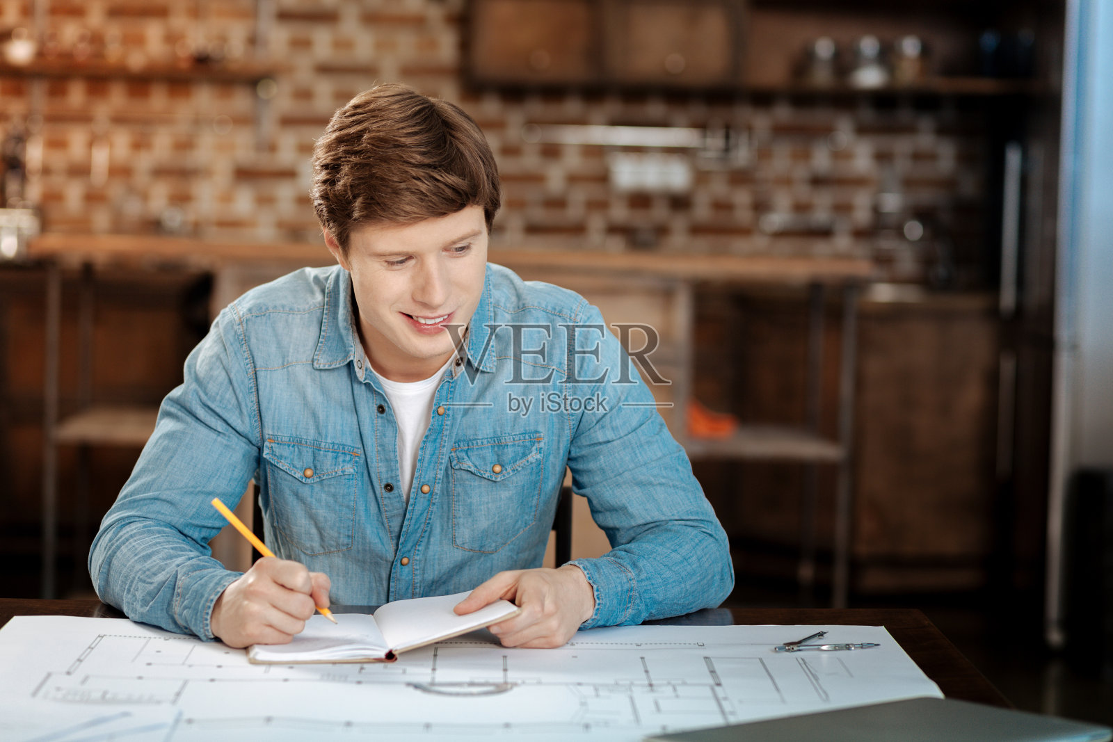 开朗的年轻工程师在为他的项目做计算照片摄影图片