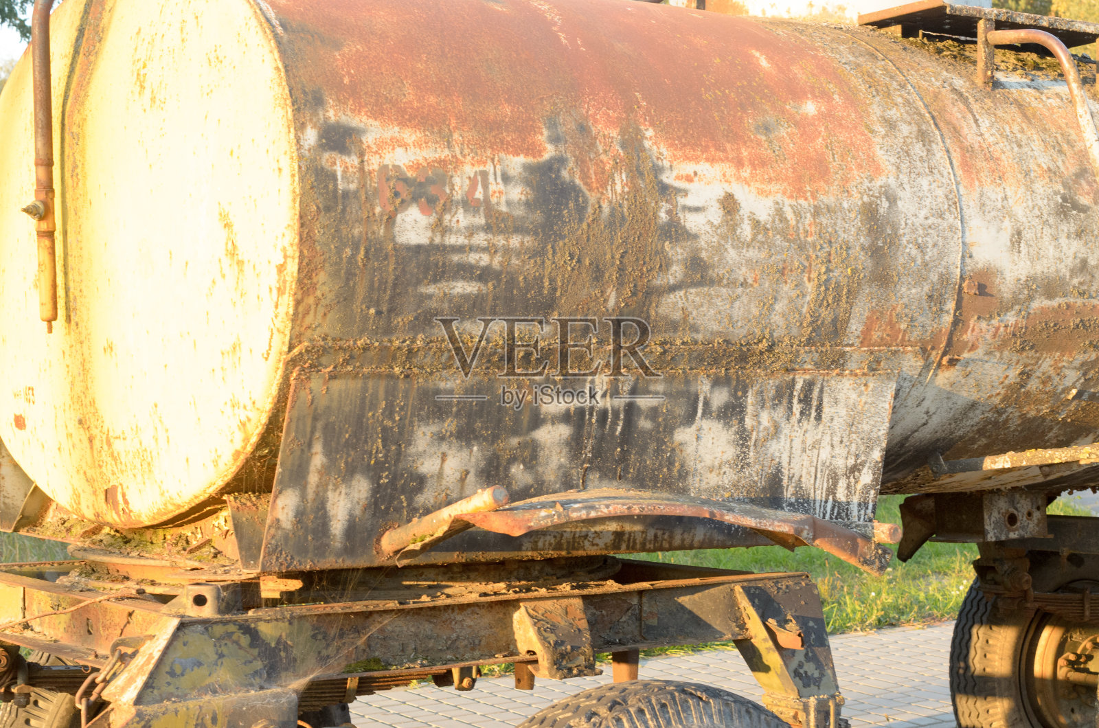 路边有一个又旧又脏的桶。照片摄影图片