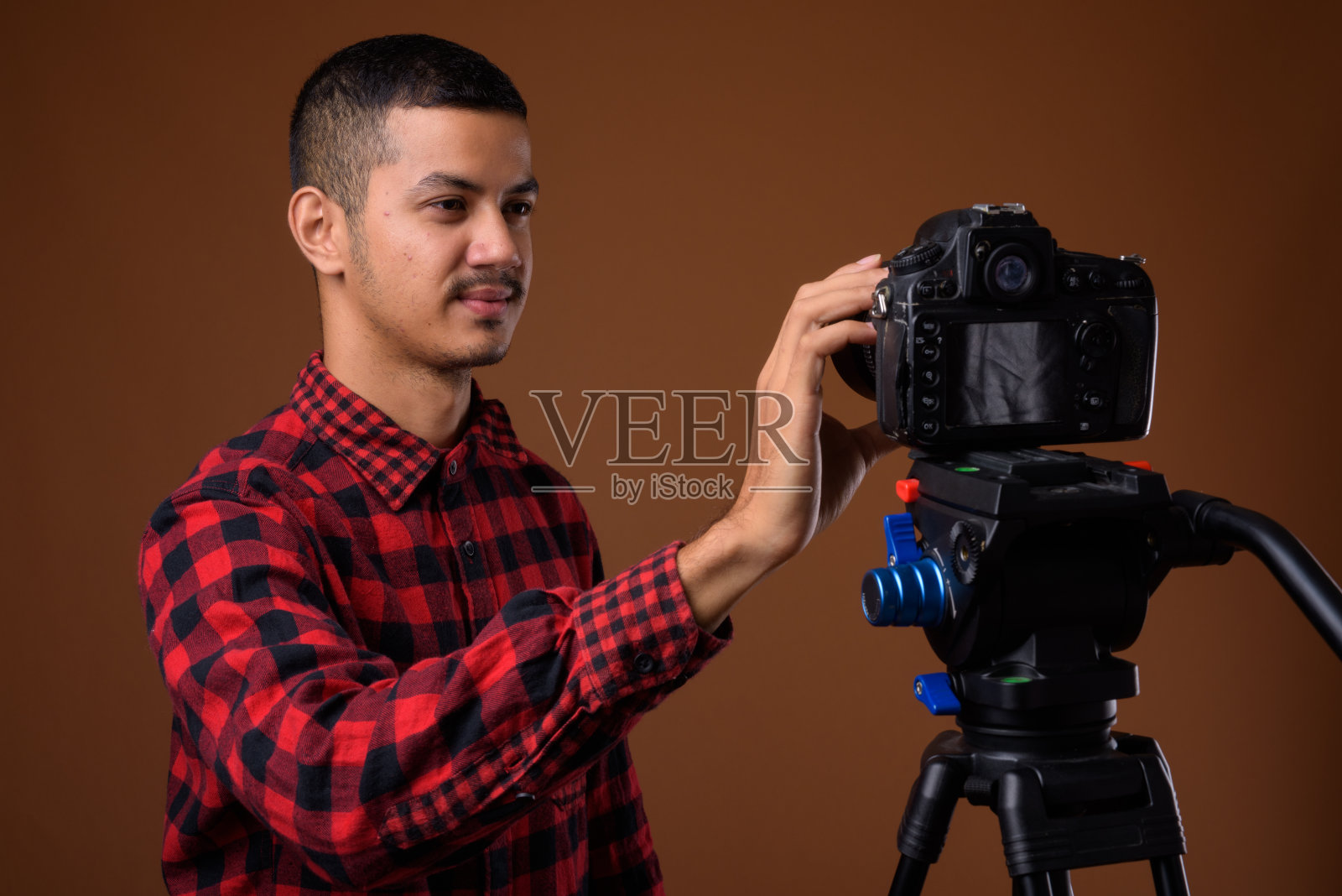 工作室拍摄的年轻亚裔男子准备在彩色背景下做视频博客照片摄影图片