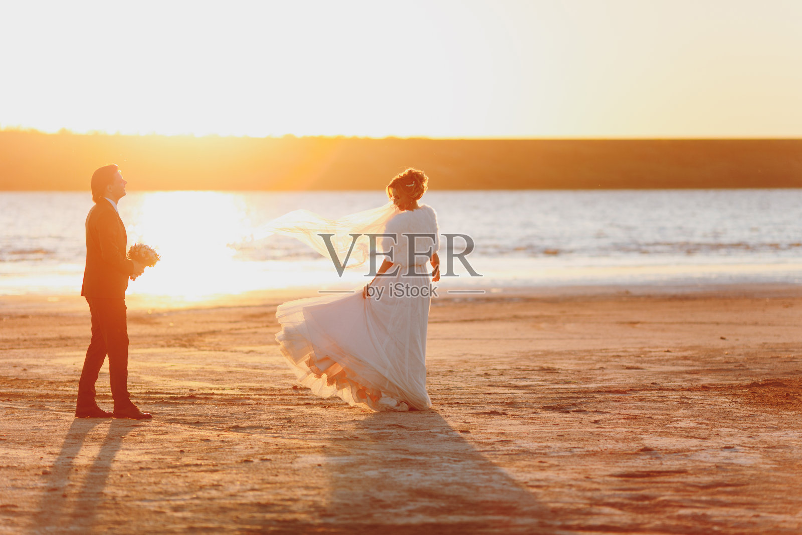 新郎和新娘在海边散步照片摄影图片