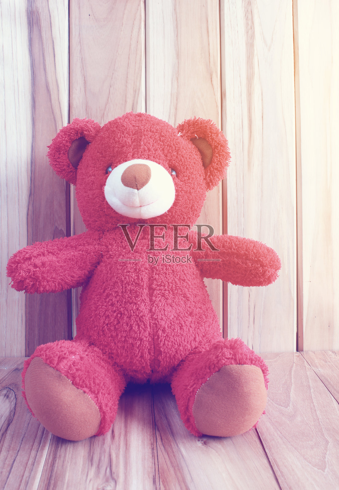 红色的泰迪熊在木地板上照片摄影图片