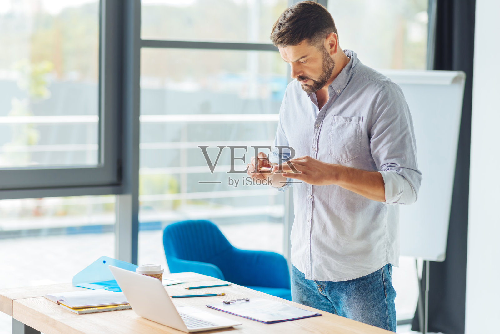 细心的黑发男性在看他的电话照片摄影图片