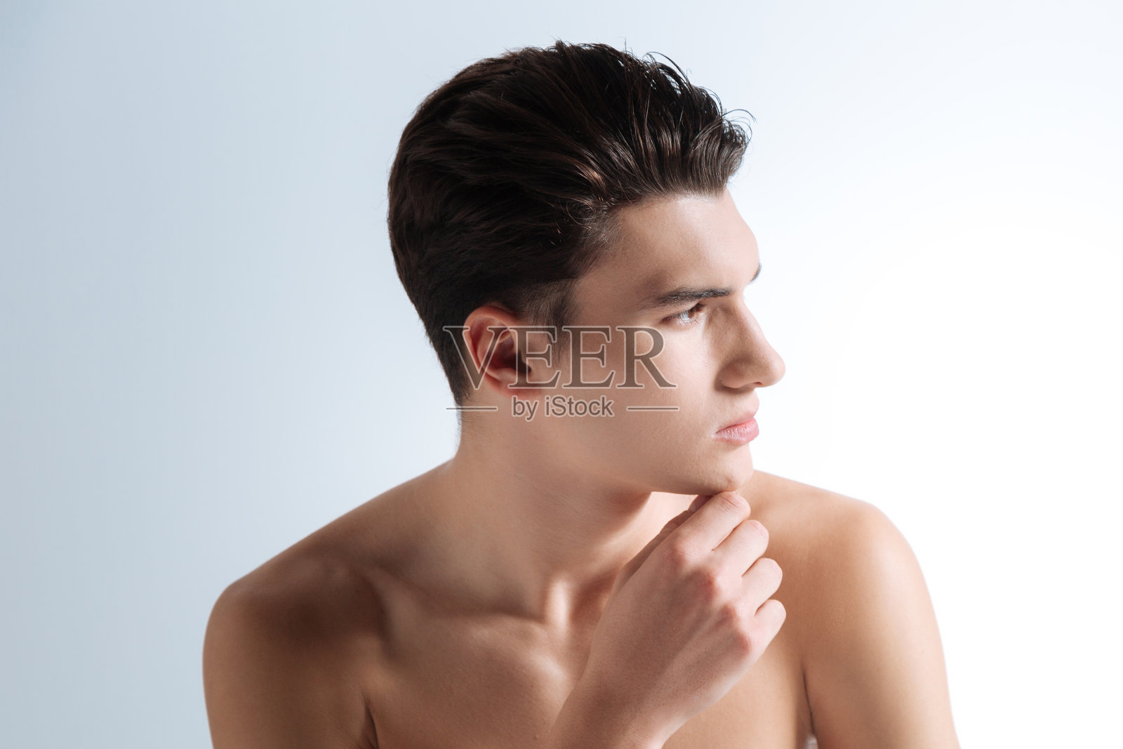 抚摸着下巴的沉思青年的肖像照片摄影图片