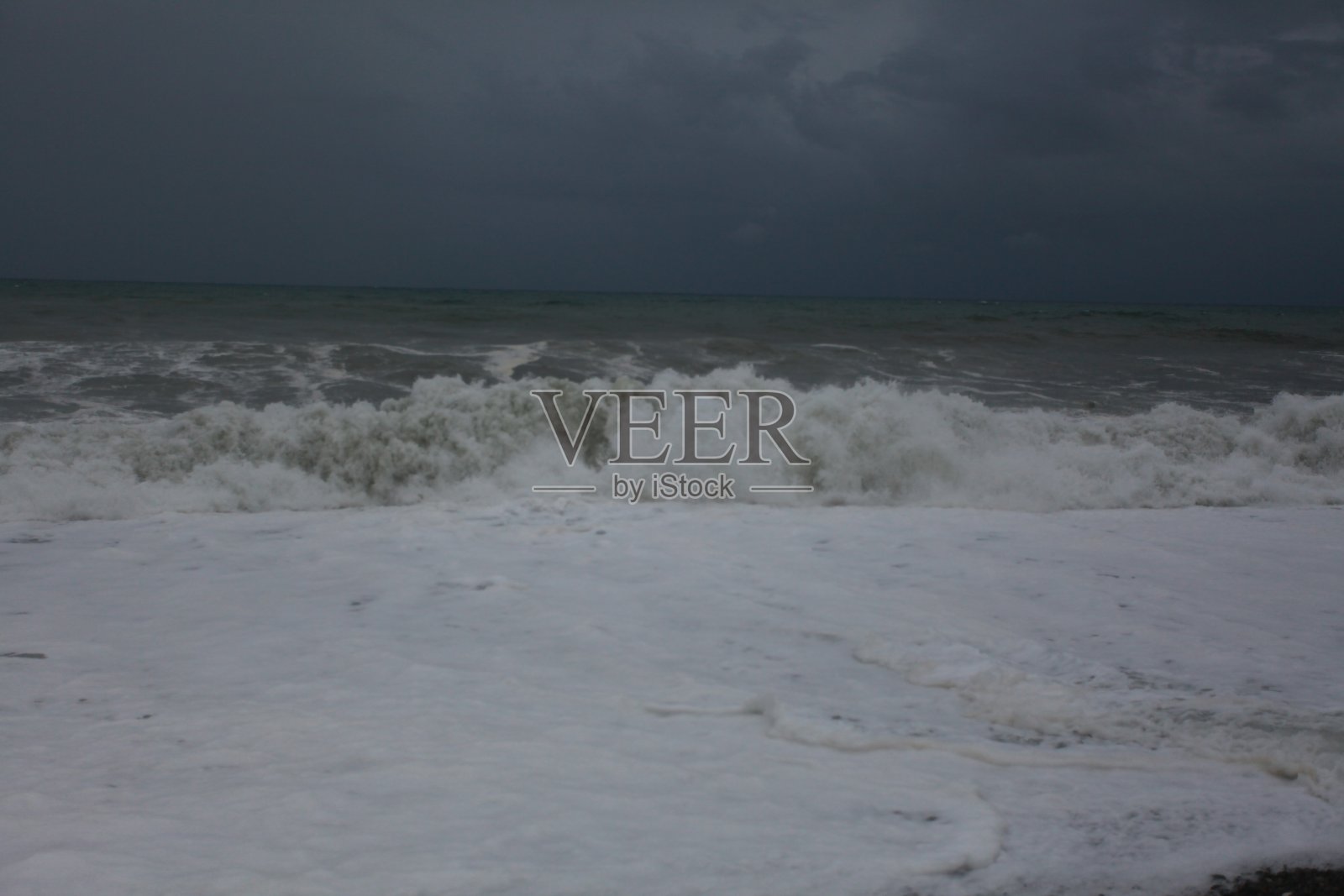 暴风雨的海浪和雨水在海滩上黑色的海照片摄影图片