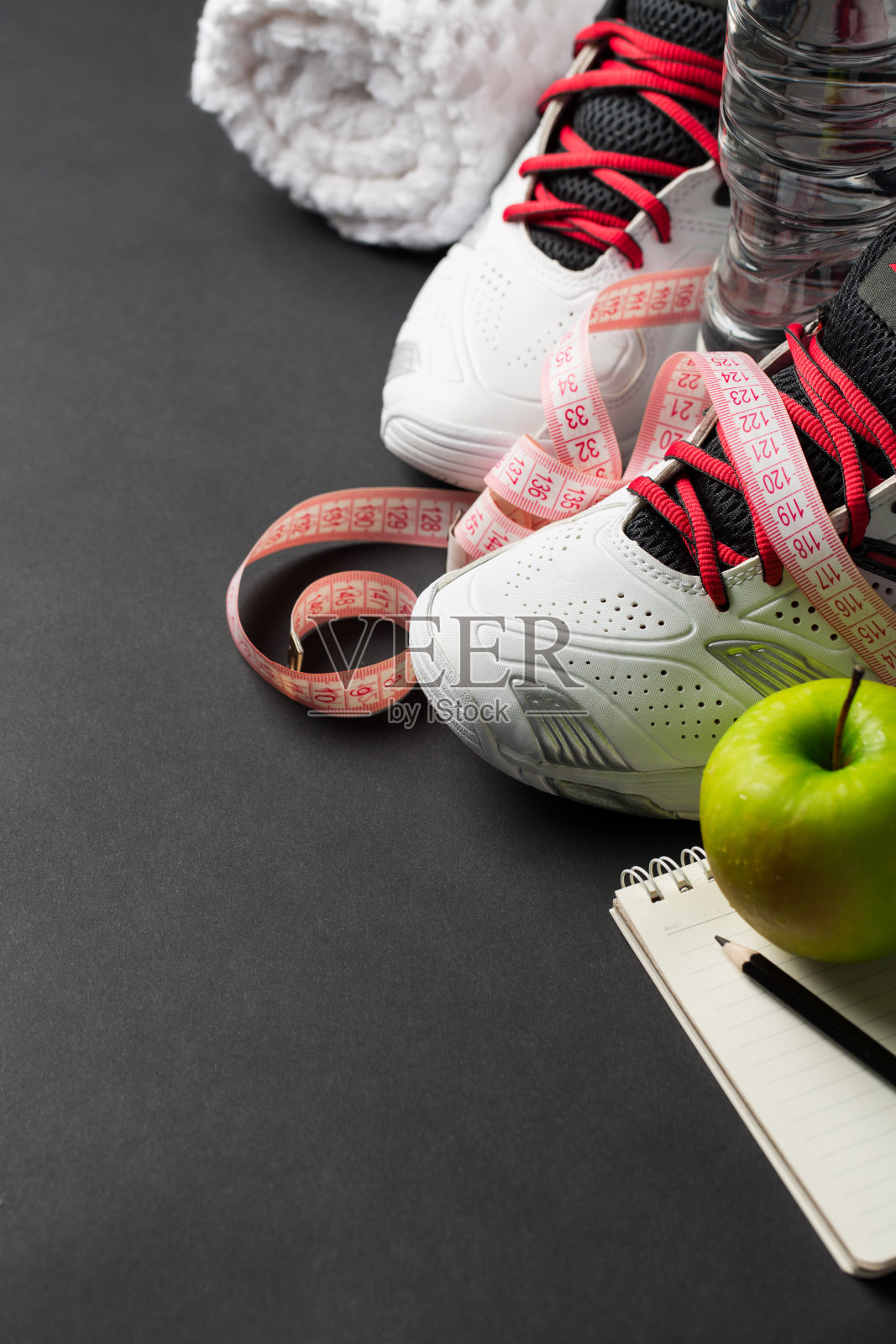 运动鞋，卷尺和灰色背景上的水照片摄影图片