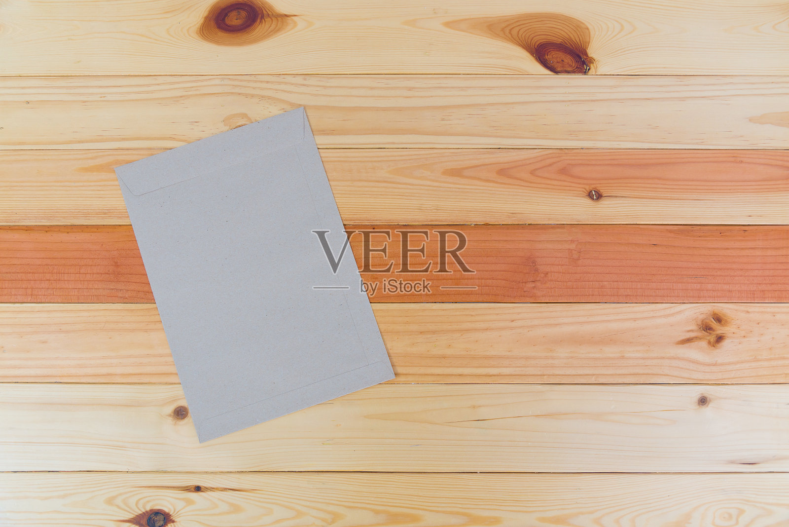 顶视图的空白棕色信封在木质办公桌与复印空间。照片摄影图片