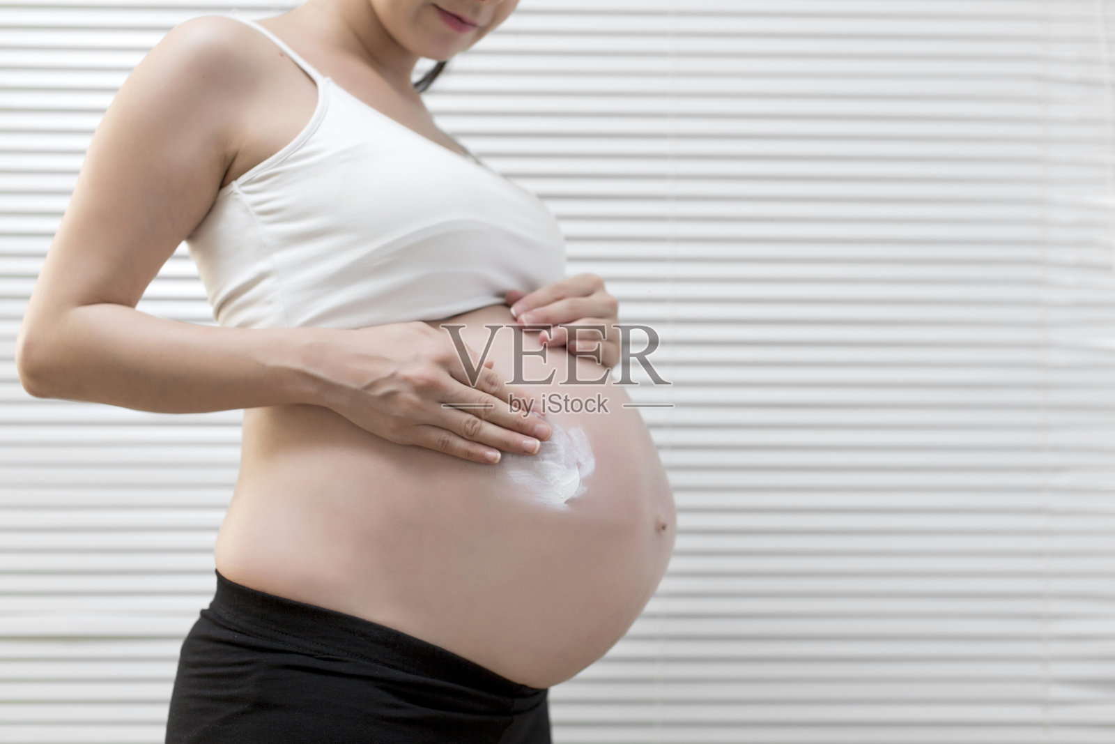 孕妇使用保湿霜照片摄影图片